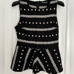 Black and white embroidered peplum top.